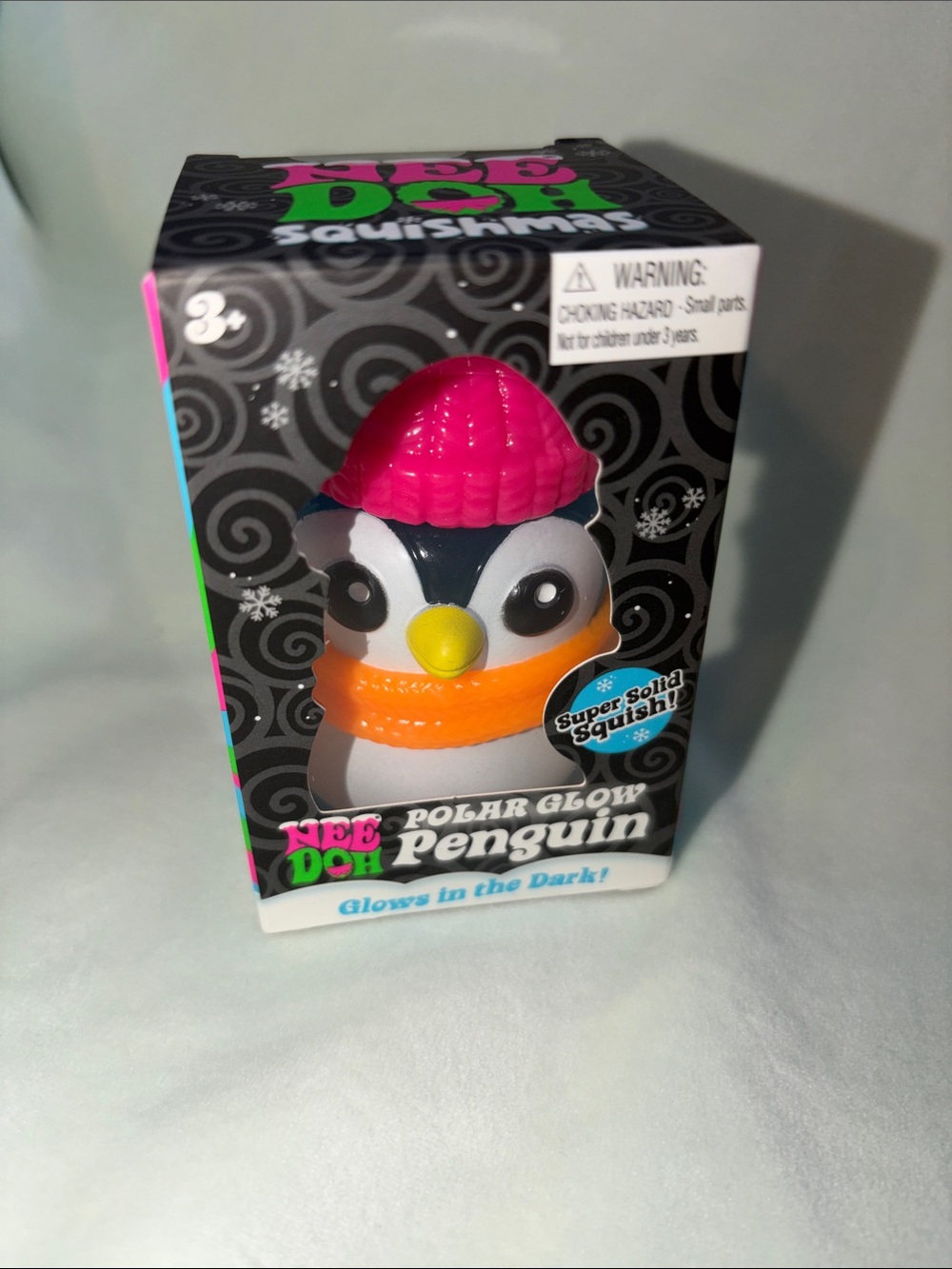 NeeDoh Polar Glow Penguin - pink hat , orange scarf